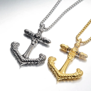 Dettaglio ciondolo ancora gotica con teschio in finiture argento e oro stile vintage