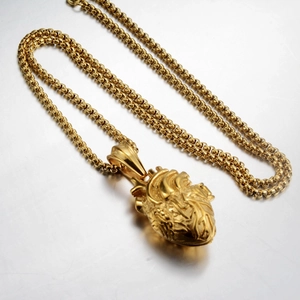 Nahaufnahme des goldenen anatomischen Herzanhängers mit Texturen an einer Punk-Kette