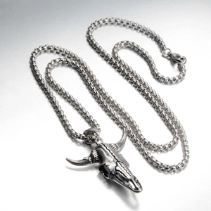 Detailed close-up of retro punk style bull skull pendant with polished steel bead chain
