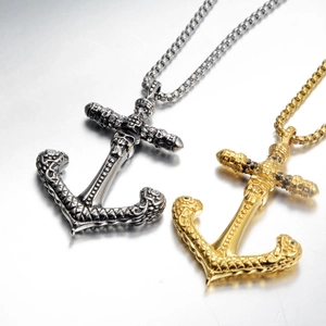 Dettaglio di ciondoli ancora punk con teschio e croce in oro e argento vintage