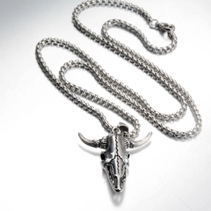 Close-up of retro punk style bull skull pendant with vintage texture and steel chain