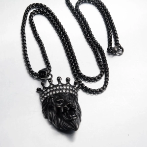 Macro view of matte black lion head pendant with crown detail and inset rhinestones