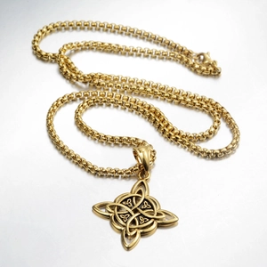 Macro shot of gold Celtic knot pendant on round box chain with secure lobster clasp