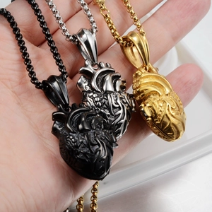 Nahaufnahme von drei anatomischen Herzanhängern in Schwarz, Silber und Gold