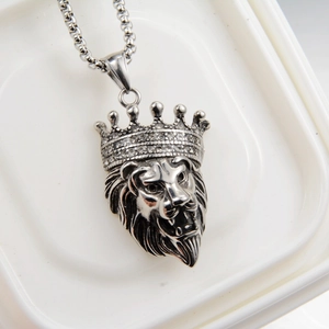 Detailed view of silver lion head pendant with crystal crown and vintage punk texture