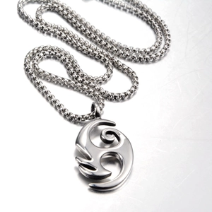 Detail of silver flame pendant with abstract cutout on box chain necklace