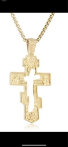Vue macro détaillée du pendentif croix orthodoxe dorée avec relief de figure religieuse