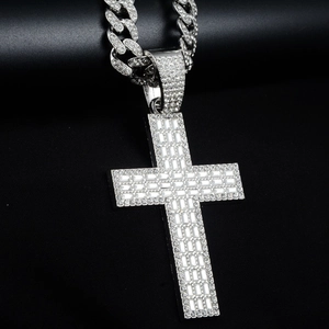 Détail du pendentif croix avec zircons baguette sur une grosse chaîne à mailles cubaines