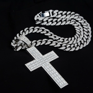 Détail du pendentif croix serti de zircons avec une chaîne cubaine en métal argenté