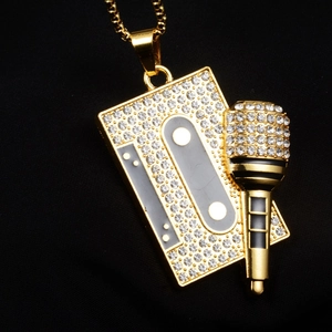 Détail du pendentif hip hop en forme de cassette et micro doré serti de zircons brillants