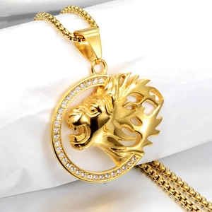 Detailopname van gouden leeuwenkop hanger met strass-montuur aan een parelketting