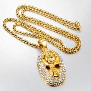 Detail of hip hop gold pharaoh pendant necklace with sparkling white rhinestones inlay
