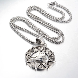 Detail of vintage silver Viking Valknut pendant with runic texture and square pearl chain