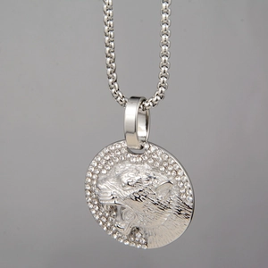 Détail d'un pendentif léopard argenté avec cristaux scintillants et tête de léopard gaufrée