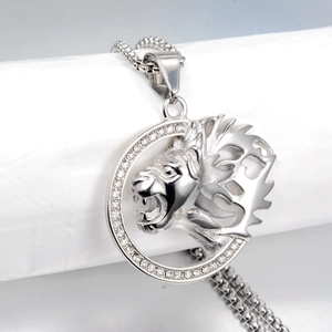 Close-up van zilveren leeuwenkop hanger met fonkelende strass-steentjes en kralenketting