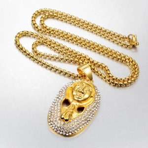 Macro detail of gold pharaoh pendant with shimmering rhinestones and thick link chain