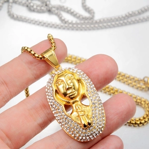 Close-up of gold pharaoh pendant with shimmering crystal inlay on a square box chain
