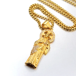 Gros plan du pendentif religieux Saint Jude doré avec strass blancs sur chaîne box