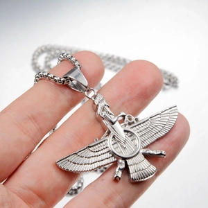 Dettaglio del ciondolo Faravahar in acciaio inossidabile argento tenuto in mano