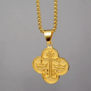 Détail macro d'un collier en acier titane doré avec croix religieuse et couronne gaufrée
