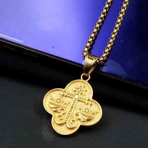 Détail du pendentif religieux doré avec croix et couronne sur une chaîne vénitienne