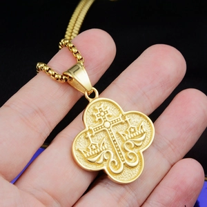 Gros plan du pendentif religieux doré montrant la croix orthodoxe et les détails de couronne