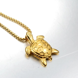 Close-up of golden sea turtle pendant featuring a box chain and 3D engraved shell texture