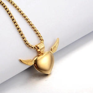Macro shot of gold heart wings pendant with detailed feathers on a round link chain