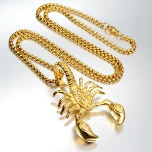 Detailed close-up of a golden scorpion pendant on a bead chain with intricate textures
