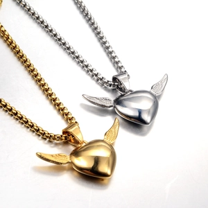 Detail of gold and silver heart pendants with wings and box chain for couples