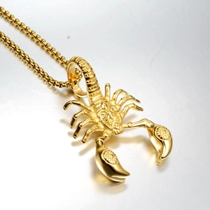 Detailed close-up of golden scorpion pendant with intricate textures on a box chain