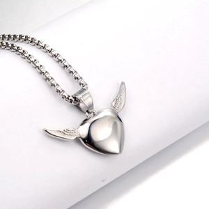 Macro detail of silver heart pendant with wings on a sturdy square bead chain