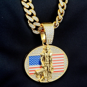 Détail du pendentif cowboy drapeau américain serti de cristaux sur une chaîne cubaine