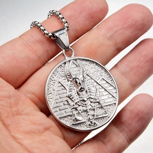 Close-up of Egyptian Anubis and pyramid relief on silver stainless steel pendant