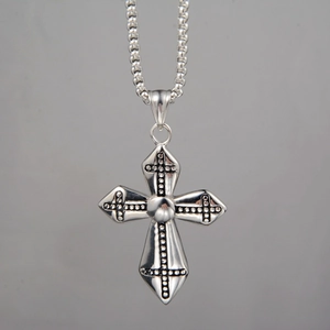 Detailed view of silver gothic cross pendant with studded texture on ball chain