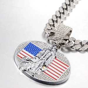 Vue macro d'un pendentif argenté avec drapeau américain sur une grosse chaîne cubaine sertie