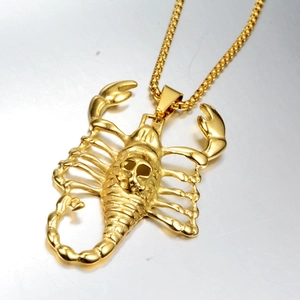 Detailed view of a gold scorpion pendant featuring a skull back on a sturdy box chain
