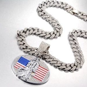 Détail d'une chaîne cubaine argentée avec pendentif drapeau américain et zircons
