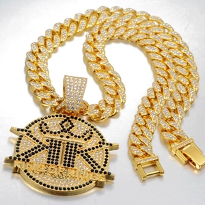 Detail view of a gold-plated Cuban chain and a round pendant with KING OF KINGS engraving
