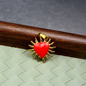 Pendente sole dorato stile hip hop con cuore rosso centrale su sfondo verde testurizzato