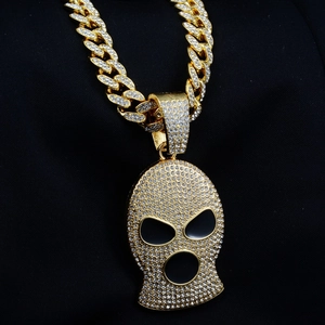 Vista macro del colgante de pasamontañas hip hop y cadena cubana gruesa bañada en oro