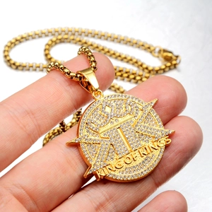 Detailed view of hip-hop gold plated pendant with crown design and iced out zircons