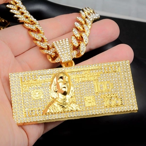 Close-up of hip-hop gold dollar sign pendant with iced-out crystals and cuban link chain