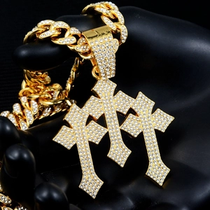 Collar hip hop con triple colgante de cruz y diamantes sobre una cadena cubana dorada