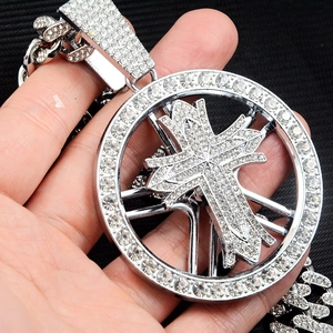 Gros plan détaillé d'un pendentif croix en argent serti de diamants sur une chaîne cubaine