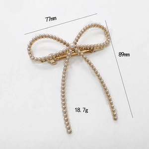 Barrette dorée élégante en forme de nœud avec perles d'imitation et franges