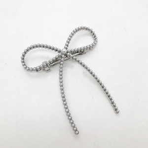 Vue détaillée de la pince à cheveux nœud en perles avec fermoir à ressort en argent
