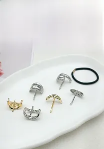 Detailed close-up of gold and silver minimalist metal hair pins and hair ties on a tray