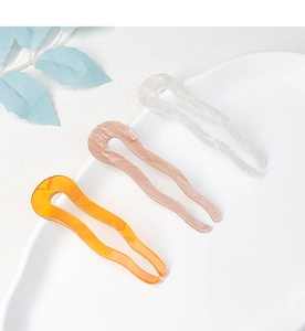 Three elegant wavy U-shaped acetate hair pins in amber, pink and marble white colors