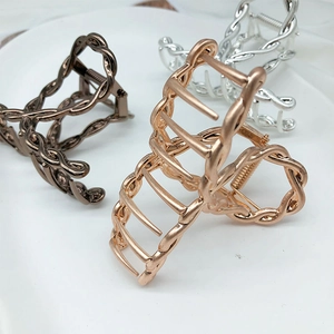 Detail view of twisted metal hair claws in rose gold, silver, and bronze finishes